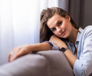 Happy woman relaxing on comfortable soft sofa enjoying stress free weekend at home, calm satisfied girl stretching on couch thinking of pleasant lazy day, dreaming and planning sunday morning