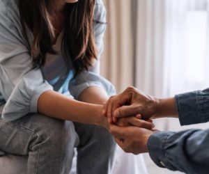 Young man comforting and supporting a sad woman who is in serious trouble at home, Consolation and encouragement concept