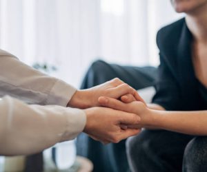 A therapist and patient are captured in a moment of connection, their hands joined in mutual support. The scene epitomizes empathy, understanding, and the silent strength that defines the therapeutic relationship.